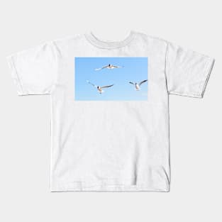 Three seagulls flying in the blue sky Kids T-Shirt